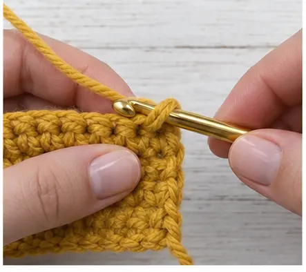 Hook inserted into the final mustard single crochet stitch