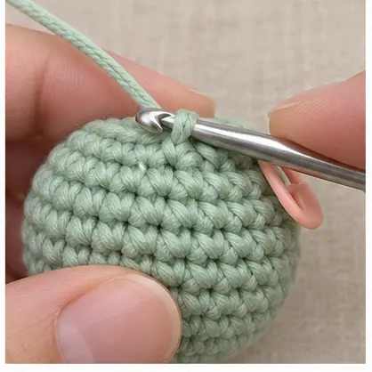 Silver hook inserted under the first front loop of mint crochet