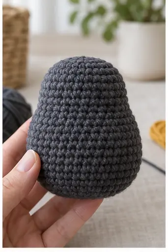 Completed charcoal pear-shaped crochet penguin body