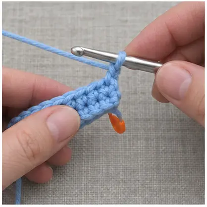 Making a turning chain at the edge of a blue crochet swatch