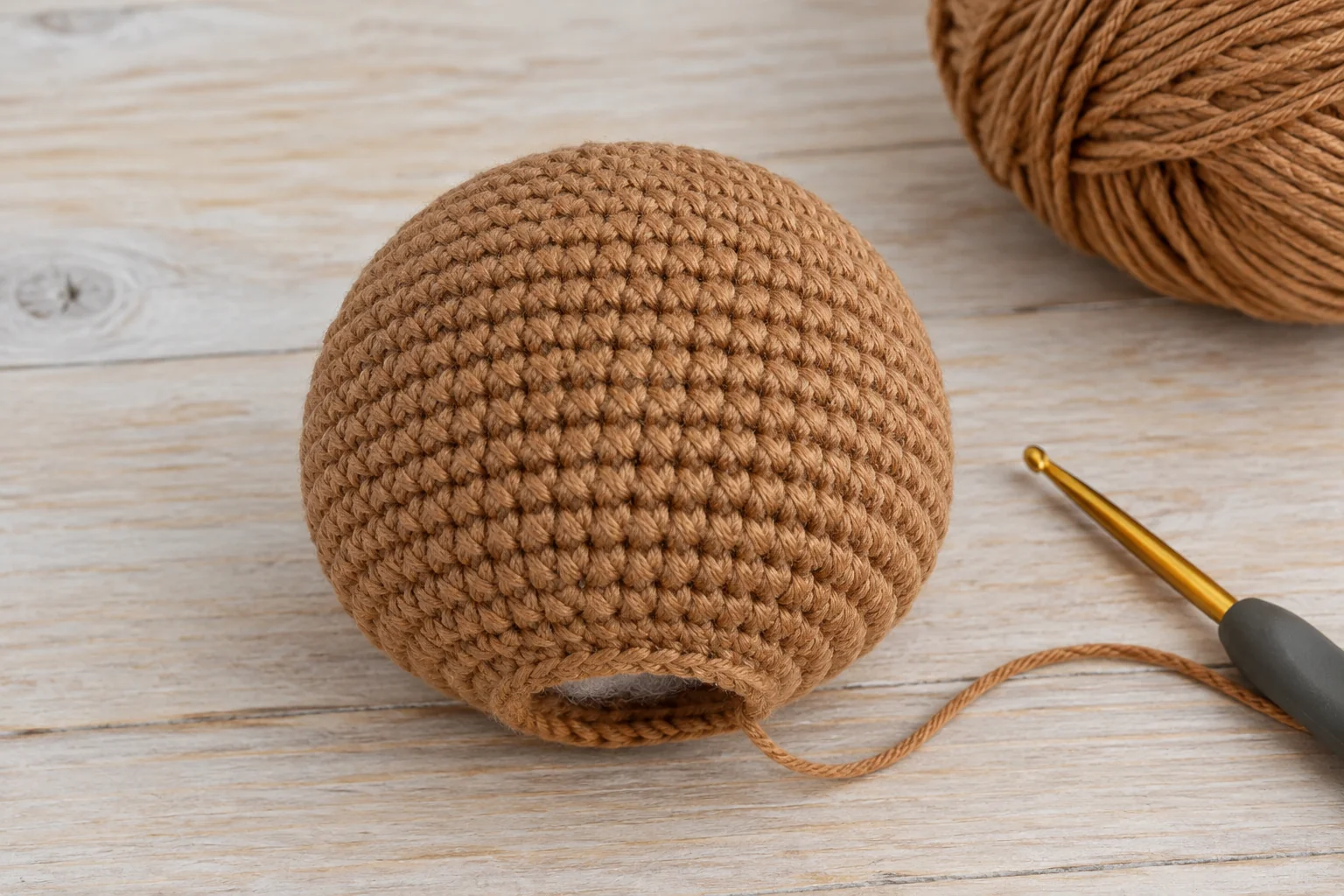 Caramel crochet bear head before facial embroidery and assembly